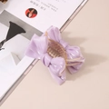 Vue détaillée d'une pince à cheveux avec nœud en maille lavande sur fond neutre - Violet