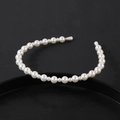 Elegant white faux pearl headband with gradient sizes on a minimalist black background - Gradient Layered Pearl Style