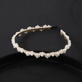 Elegant gold headband featuring clustered white pearls and protective black ear tips - Clustered Dense Pearl Style