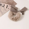 Detail of plush hair tie with houndstooth bow and pearl accent on a fashion magazine - Houndstooth-Grey Brown