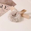 Detail of plush beige hair tie with large white pearl and elegant satin bow ornament - Solid-Milk Coffee