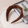 Close-up of caramel brown ruched headband with plush velvet texture on a white plate - Caramel color