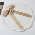 Elegant champagne gold satin ribbon hair clip with long tails on a ceramic tray - Khaki