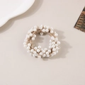 Détail de perles blanches élégantes sur un chouchou tressé à haute élasticité - Perle Blanche Fil d'Or