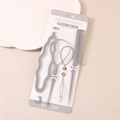 4-teiliges graues Haarstyling-Set mit Stielkamm und Haarschleifen auf weißer Kartonverpackung - Grau