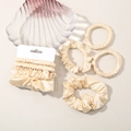 Close-up of champagne silk satin hair scrunchies set with elegant decorative shell - Milky Yellow
