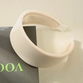 Cerchietto largo plissettato beige chic con strisce testurizzate su libro di moda - Bianco Crema