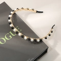 Elegant gold metal headband featuring white pearls and black faceted beads on a vintage book - Black Crystal Artificial Pearl Style