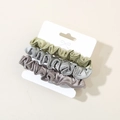 Three-pack elastic satin scrunchies in green, grey, and purple on display card - Cool Mixed Colors