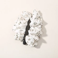 Banana hair clip with cream floral fabric and green leaf print on a black base - Bulk Packaging / Beige Floral