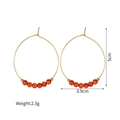 Dettaglio di grandi orecchini a cerchio dorati con perline arancioni da 5cm - Stile con Perline Rosse (S-E1192-hong)