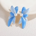 Détail macro de boucles d'oreilles pétales bleu dégradé avec perle centrale sur céramique - Bleu