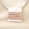 Set of four champagne silk satin scrunchies with elegant pleated texture on a display card - Lotus Pink