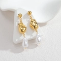 Dettaglio degli orecchini con perle barocche e elementi metallici in texture lava dorata - Oro