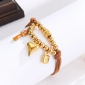 Detail of golden beaded bracelet with heart, key, and lock charms on brown cord - Heart Key Lock Style (OLBB1296-B)