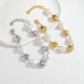 Detailed close-up of gold and silver irregular baroque pearl bracelets with lobster clasp - Bracelet B1292 / Steel