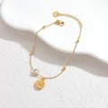 Detailaufnahme eines goldenen Edelstahl-Armbands mit Sonnenblumen- und Herzkristallanhänger - Sonnenblume (Gold)