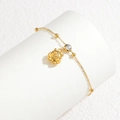 Détail du bracelet chaîne dorée avec zircon rond et pendentif chat sur support blanc - Style Hibou Doré
