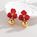 Detalle de pendientes de flores esmaltadas en rojo con colgante de esfera dorada - Rojo