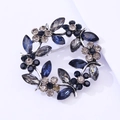 Close-up of blue and grey crystal wreath brooch with silver-tone base and metal pin back - Vintage Silver Grey And Dark Blue