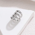 Minimalist silver multi-layer spiral stainless steel ear cuff on a stone display stand - Silver Tone (S-E1252)