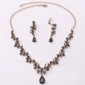 Macro view of bridal jewelry set featuring pear-shaped smoky crystals and gold alloy - Antique Gold Transparent Black Zircon Necklace + Ear Clip