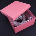 Detailansicht einer rosa geprägten Schmuckschatulle mit zarter Rosentextur und Zubehör - Rosa Geprägte Schmuckschatulle