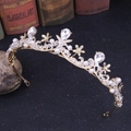 Nahaufnahme der goldenen Brautkrone mit Kristallblumen und weißen Perlen auf schwarzem Grund - Gold (Handgefertigt Perlen)
