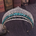 Close-up of golden crown with peacock pattern, featuring green pear-cut rhinestones - KC Gold With Green Crystals