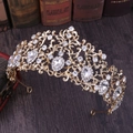 Detailed view of a gold bridal crown with crystals on a vintage wooden background - KC Gold White Rhinestone