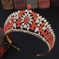 Dettaglio di un lussuoso diadema d'oro con strass rossi e bianchi su libro d'epoca - Base Oro Strass Rosso