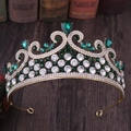 Détail d'une couronne de mariée vintage dorée avec gemmes vert émeraude et petits cristaux blancs - Or avec strass verts