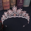 Detailansicht der roségoldenen Brautkrone mit rosa Kristallen auf Vintage-Büchern - Roségold Pfirsich Strass