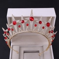 Nahaufnahme der goldenen Brautkrone mit roten Sternsteinen und funkelnden Kristallen - Gold mit roten Strasssteinen