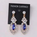 Detailed macro view of vintage gold earrings with blue marquise stone and sparkling rhinestones - KC Gold Blue Rhinestone (Post)