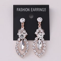 Macro view of rose gold long drop earrings featuring white rhinestones and marquise cut gem - Rose Gold White Rhinestone (Post)