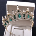 Gros plan du diadème de mariée doré avec pierres d'émeraude vertes et perles blanches - Or avec strass verts