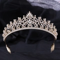 Makroaufnahme einer goldenen Barock-Tiara mit Kristallblüten auf schwarzem Stoff - KC Gold mit weißen Strasssteinen