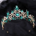 Vue détaillée de la couronne baroque de luxe avec cristaux verts et strass sur base dorée - Or avec strass verts