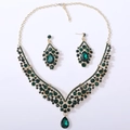 Detailed close-up of emerald green crystal teardrop necklace and matching earrings jewelry set - Gold Tone All Green Rhinestone