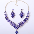 Detail view of gold bridal jewelry set with pear-cut deep blue crystals and teardrop pendant - Gold Tone All Blue Rhinestone
