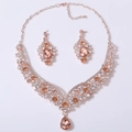 Close-up of champagne crystal teardrop necklace and earrings set in rose gold plating - Rose Gold Tone Champagne Rhinestone
