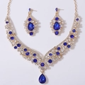 Detail view of navy blue teardrop crystal necklace and earrings set on golden alloy base - Gold Tone White And Blue Rhinestone