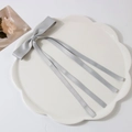 Barrette à cheveux élégante avec nœud en satin gris clair sur un plateau en céramique - Gris