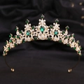 Detail view of gold bridal crown with emerald crystals on black velvet background - KC Gold White Diamond + Green Diamond