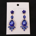 Detail of drop earrings with deep blue teardrop gems and sparkling crystal accents - Gold Blue Earring Post Earrings