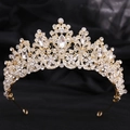 Dettaglio ravvicinato di corona dorata con strass trasparenti e cristalli a forma di pera - Oro Zircone Bianco