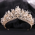 Detalle de corona nupcial dorada con pedrería engastada sobre fondo de tul negro texturizado - Estilo Oro KC Diamantes Blancos