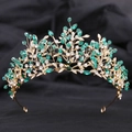 Detail of leaf-themed bridal crown with green crystals and gold wire on black background - Gold White Green