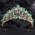 Détail macro d'une couronne de mariée dorée avec gemmes vert émeraude et cristaux blancs - Or Zircon Vert